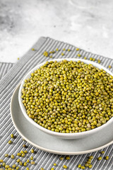 Mung. Mung green beans in a ceramic bowl on a light gray kitchen table. Legume plant for a healthy diet	