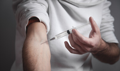 Drug addict man with a syringe. Addiction
