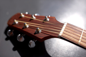 music and musical instruments concept - close up of acoustic guitar head with pegs
