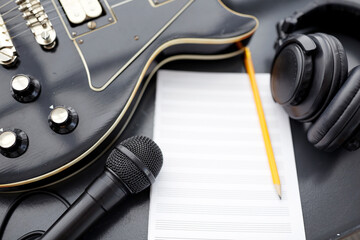 composing and music writing concept - close up of bass guitar with music book, microphone and...