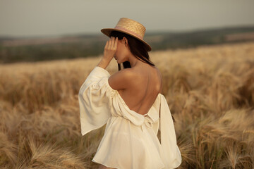 Portrait of a happy woman with long hair that is in the field of wheat.