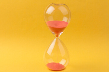Crystal hourglass on yellow background as a concept of passing time for business term, urgency and...