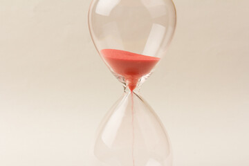 Crystal hourglass on champagne background as a concept of passing time for business term, urgency and outcome of time.