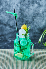 Lemonade with lemon, ice , straw and mint in the dark background