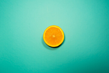 Slice of orange on blue background cut fruit