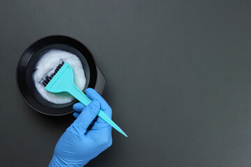 barber mixes the hair dye with a brush in a bowl