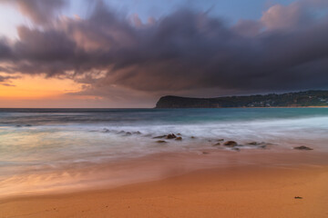 Sunrise at the seaside with rain clouds rolling in