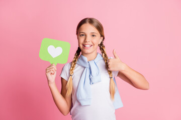 Photo portrait cheerful smiling schoolgirl wearing white shirt showing like sign thumb-up gesture isolated on pastel pink color background