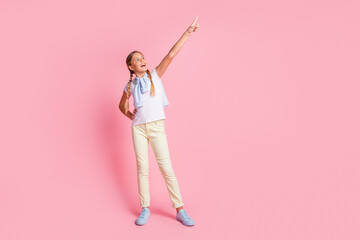 Full size photo of young girl look point finger empty space demonstrate look jumper on shoulders isolated over pastel color background