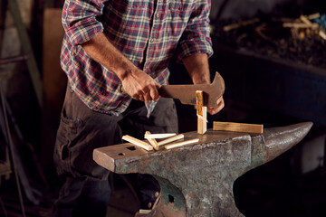 Close Up Of Male Blacksmith Chopping Wood For Kindling On Anvil To Light Forge