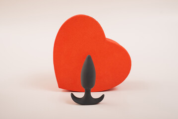 Heart-shaped box and butt plug on a white background. Love on February 14.