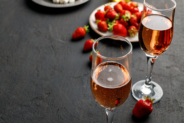Plate with fresh strawberry and glass of wine on black background