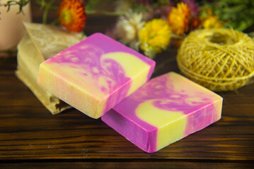 Natural handmade skincare. Handmade natural soap, candles and flowers on the dark wooden countertop.