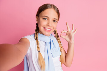 Photo of schoolgirl happy smile make selfie show okey sign jumper on shoulders isolated over pastel color background