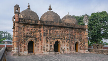 Fototapeta na wymiar View of ancient Nayabad rural mosque with terracotta facade in Dinajpur district, Bangladesh
