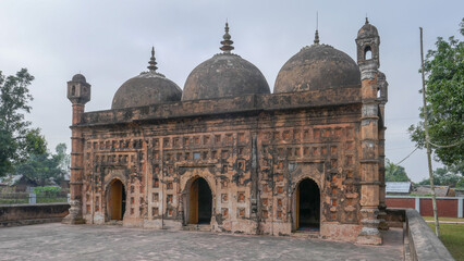 Fototapeta premium View of old Nayabad countryside mosque with terracotta facade in Dinajpur district, Bangladesh