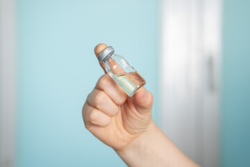 Coronavirus vaccine bottle. Phial with vaccine against COVID-19 in scientis's hand in research...