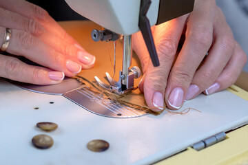 Woman sews on a sewing machine.