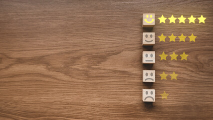 Top view of wooden cube with icon of face expression of rating a stars.Customer experience concept.