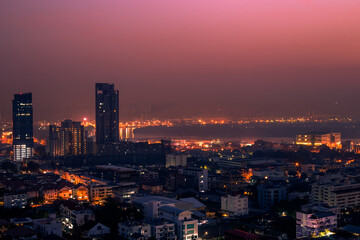 Obraz premium The high angle background of the city view with the secret light of the evening, blurring of night lights, showing the distribution of condominiums, dense homes in the capital community