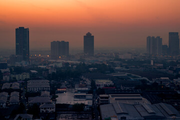 The high angle background of the city view with the secret light of the evening, blurring of night lights, showing the distribution of condominiums, dense homes in the capital community