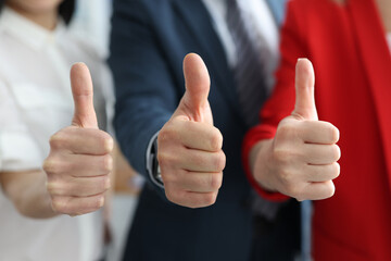 Businessman and businesswomen showing ok gesture with thumbs up