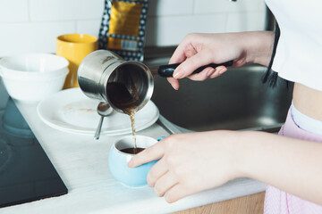 Fototapeta na wymiar girl preparing coffee in the kitchen