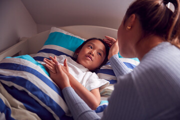 Asian Mother Talking To Daughter In Top Bunk Bed Before She Goes To Sleep