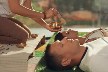 Couple at healing session with singing bowl indoors