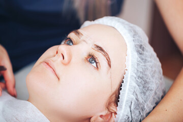 Cosmetolog beauty master making marks before the permanent makeup procedure
