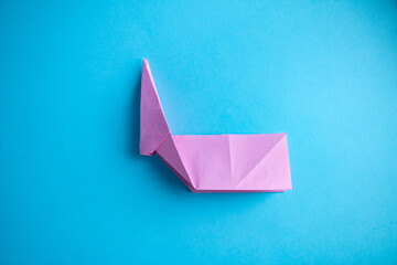 Step-by-step instructions for creating  origami bunny out of colored paper on  blue background, for  decorative Easter party decoration or for small Easter gifts.