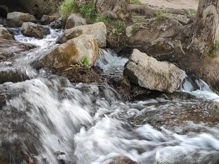 Water flows through the stones of a small waterfall