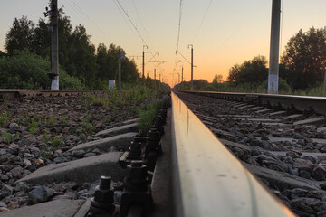 The sky is reflected by the railway rails stretching into the distance