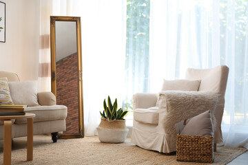 Elegant mirror near sofa in stylish living room interior