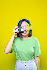 young beautiful asian woman taking pictures with retro vintage photo camera