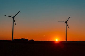 Obraz premium Beautiful sunset with silhouettes of wind power plants near Kugl, Bavaria, Germany