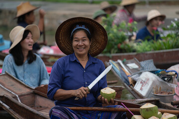 Middle age local women selling noodel on boat.Asian tourists  local markets. Floating market It is...
