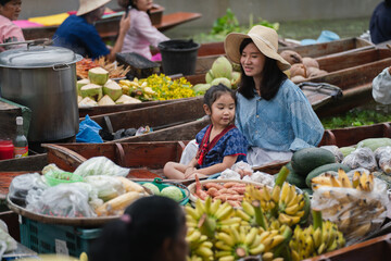 Asian tourists are enjoying of selling products in local markets. Floating market It is famous in Thailand called Tha Kha Floating Market in Samut Sakhon Province.