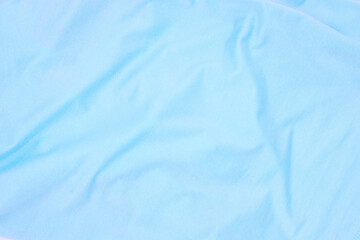 Pale blue fabric top view. Colored textile photo texture. Folded fabric with wrinkles for pattern mockup. Blank textile surface. Fashion or retail industry banner template