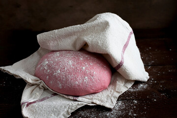 Pink beet root bread dough under cloth