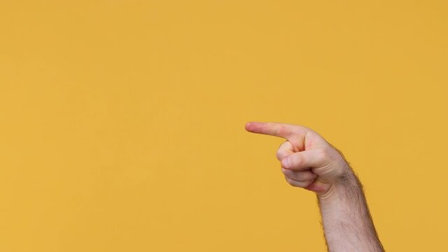 Cropped close up man male hand doing phone gesture like says call me back pointing finger aside showing thumb up like sign isolated on yellow background studio. Copy space Advertising workspace mockup