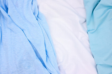 Blue and white fabric top view photo. Gentle colored textile photo texture. Folded fabric with...