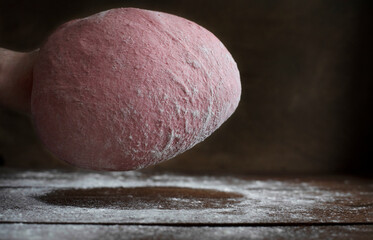 Hand holding pink beet root bread dough
