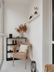 Beautiful white loggia in scandinavian style with rattan chairs, white pillow, black shelf, vases, pampas grass, candles. Nordic, higgle concept.