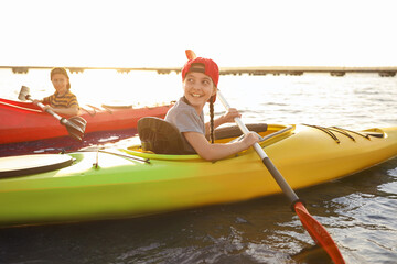 Little children kayaking on river. Summer camp activity