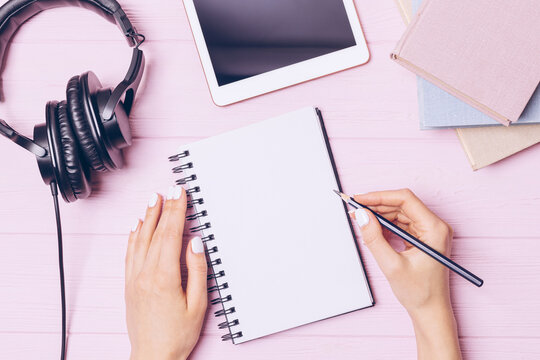 Doing homework female hands write in blank notebook