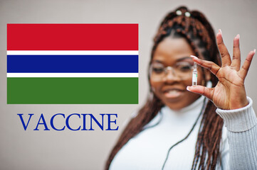 African woman show vaccine for Republic of The Gambia. Vaccination of Africa countries concept.