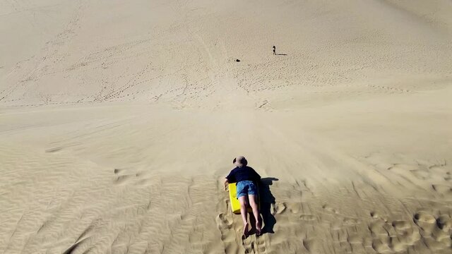 A person sandboarding at the 90-mile beach in Cape Reinga New Zealand in HD