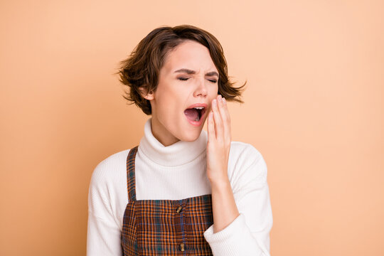 Photo portrait of lazy schoolgirl tired after classes yawning closed eyes isolated on pastel beige color background
