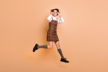 Fototapeta na wymiar Full size profile photo of optimistic short hairdo girl jump run wear dress socks shoes isolated on peach background